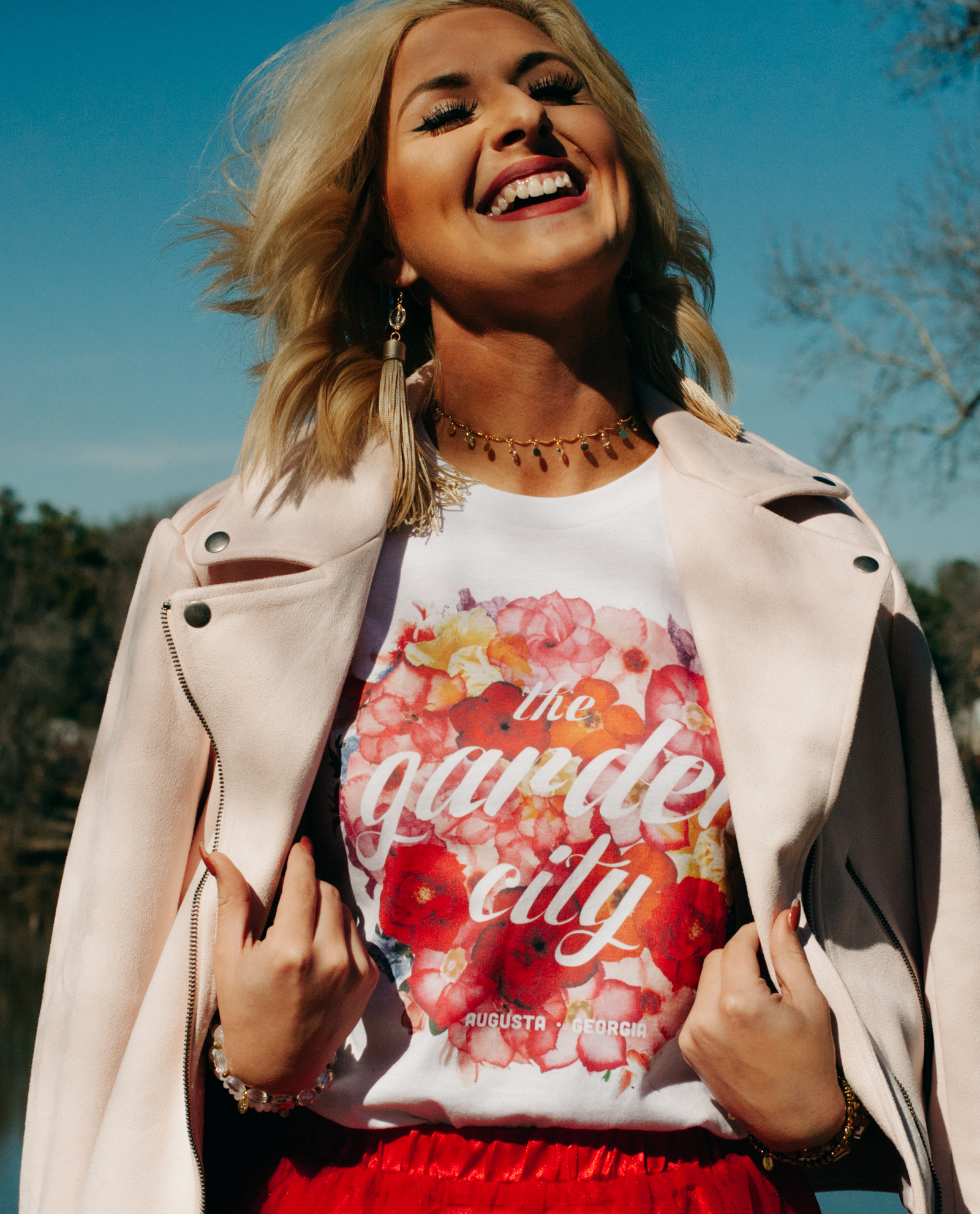 Woman wearing white Floral Garden City shirt with red skirt and jacket