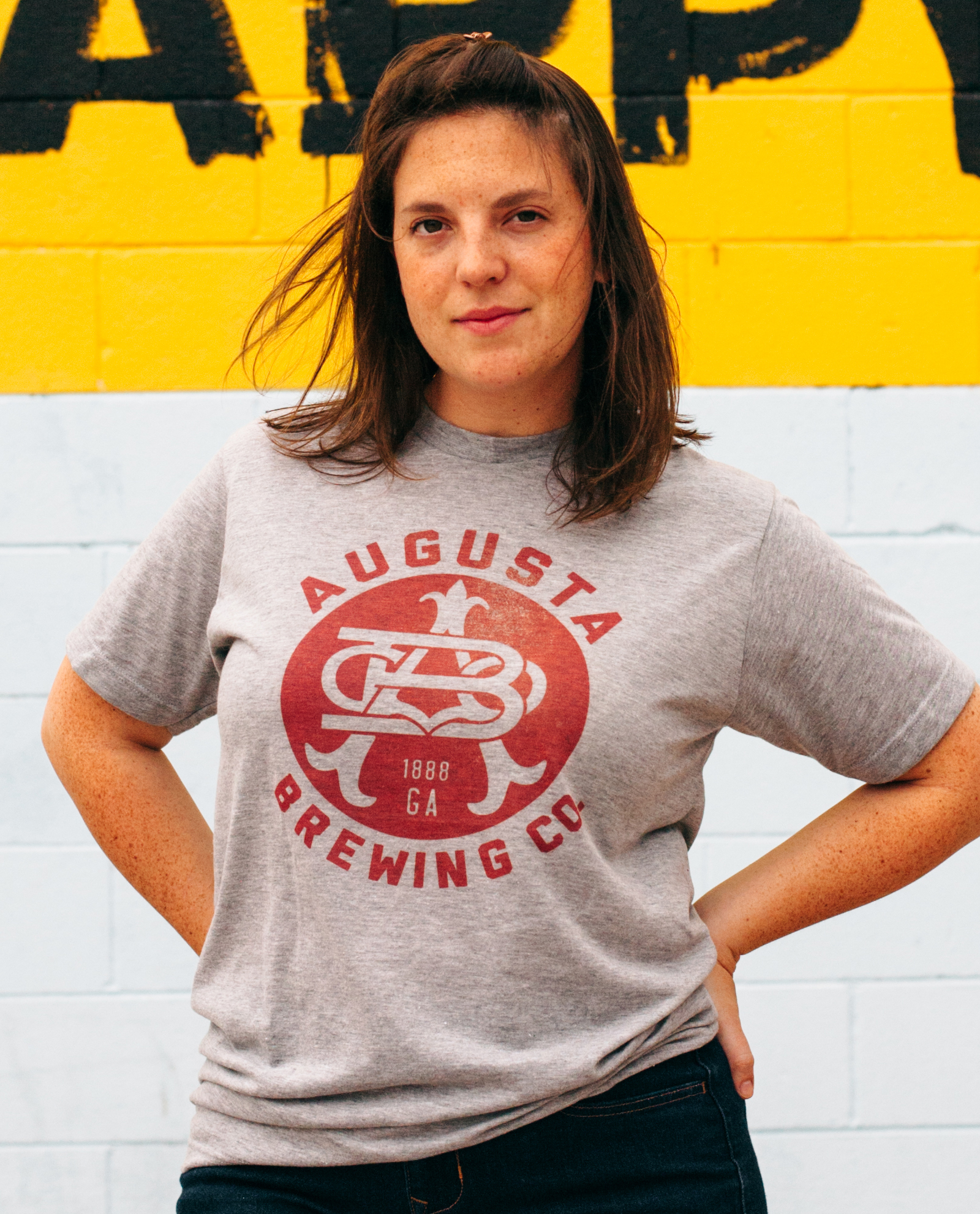 Woman with hands on hips wearing Augusta Brewing shirt