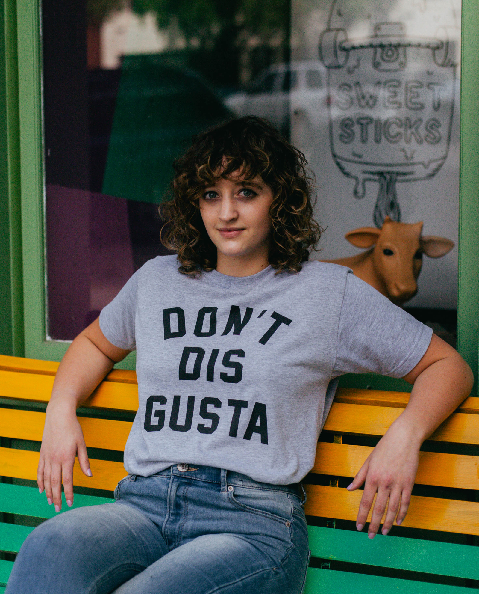 Woman sitting on a bench wearing gray Don't Dis Gusta shirt