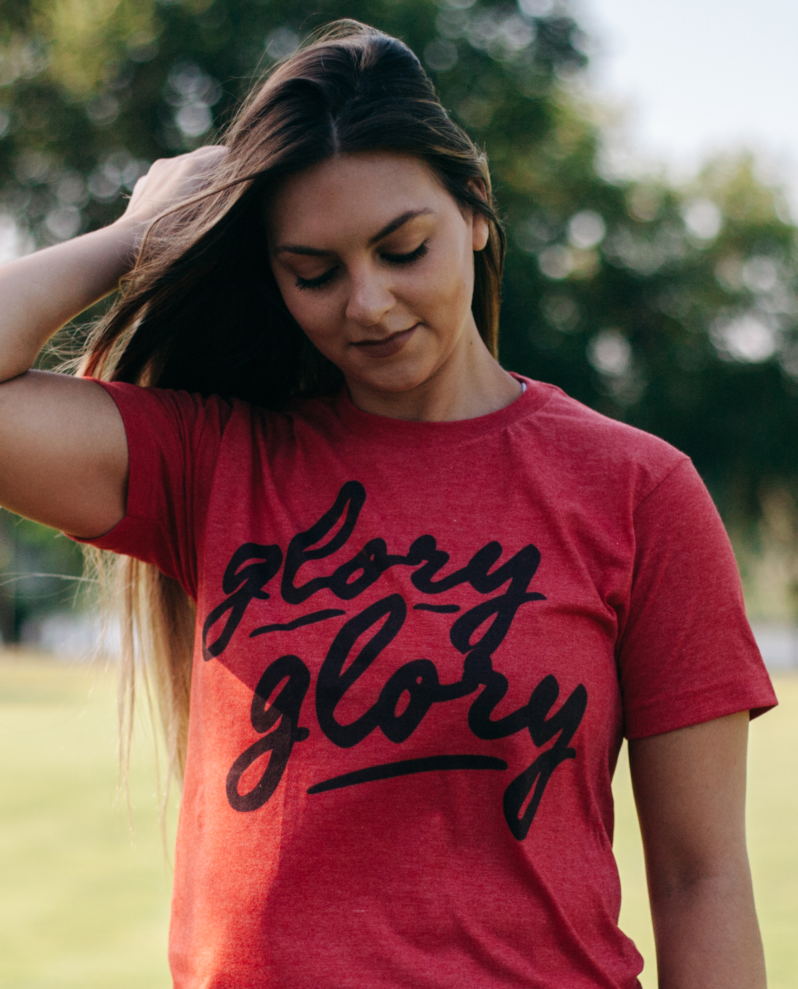 Woman wearing red Glory Glory shirt with hand in her hair