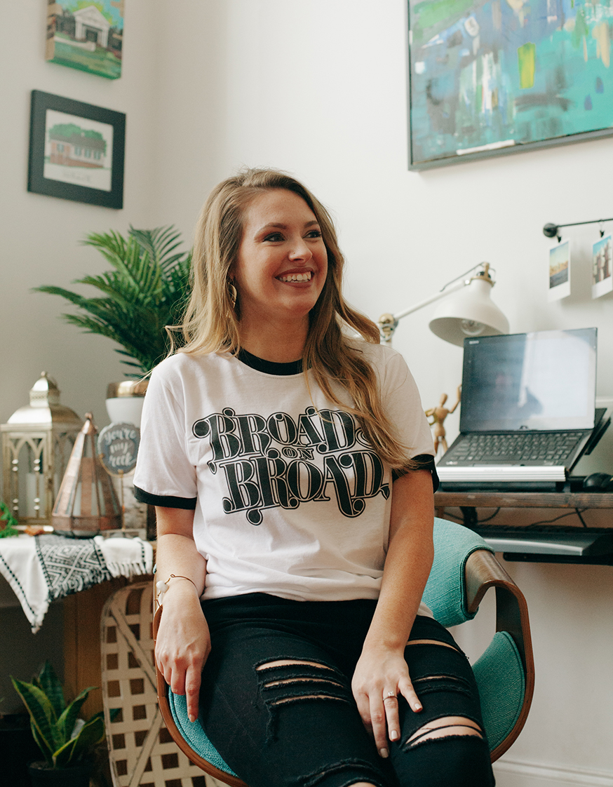 Woman sitting next to computer and wearing Broads on Broad shirt