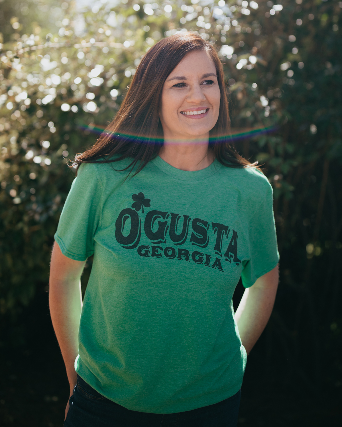 Woman wearing green Augusta Georgia St. Patrick's Day shirt with jeans